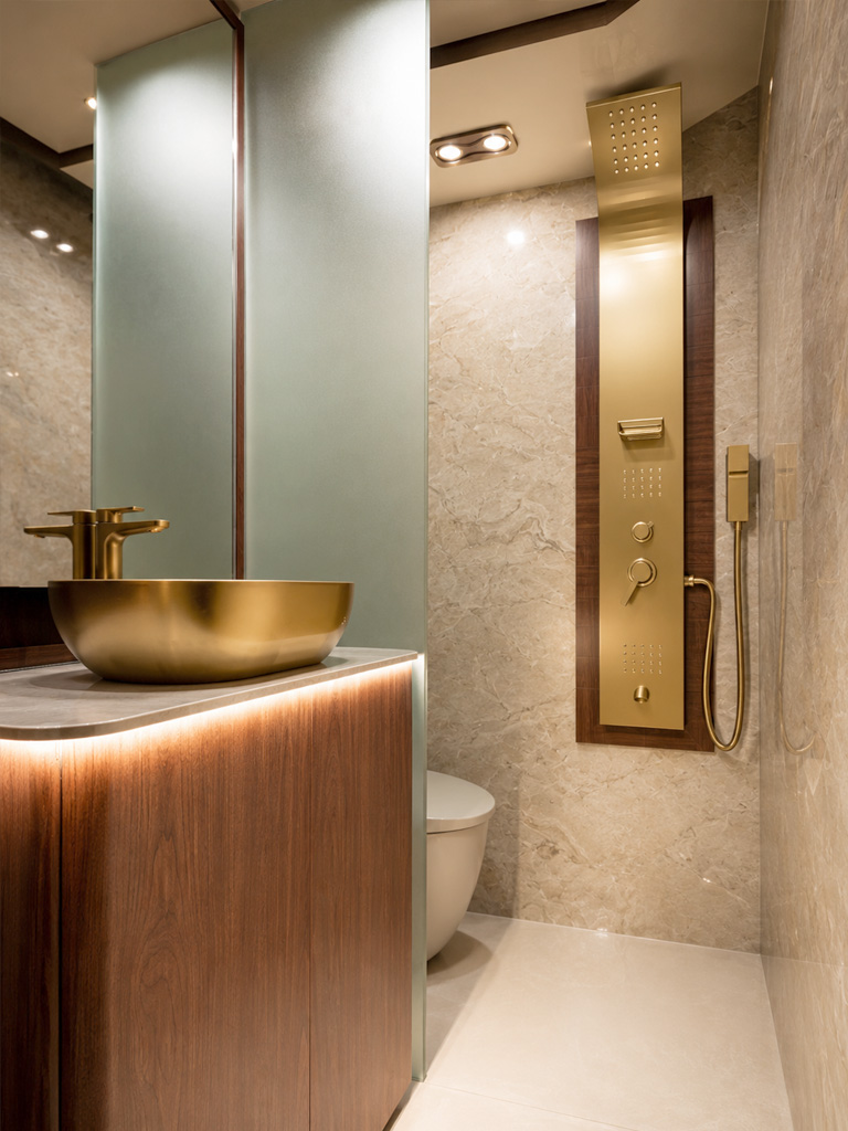 Washroom with marble walls, gold basin and rain shower panel